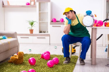 Genç erkek müteahhit partiden sonra ev işi yapıyor.