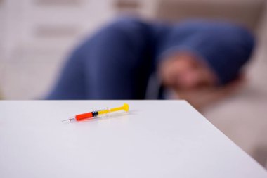 Evde narkotikle sorunları olan genç bir adam.