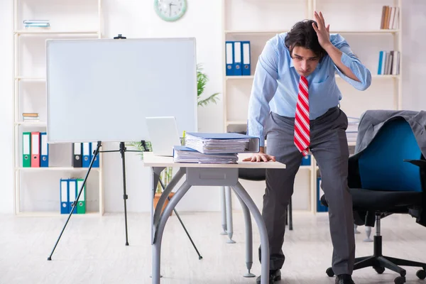 Joven empleado masculino infeliz con el trabajo excesivo — Foto de Stock