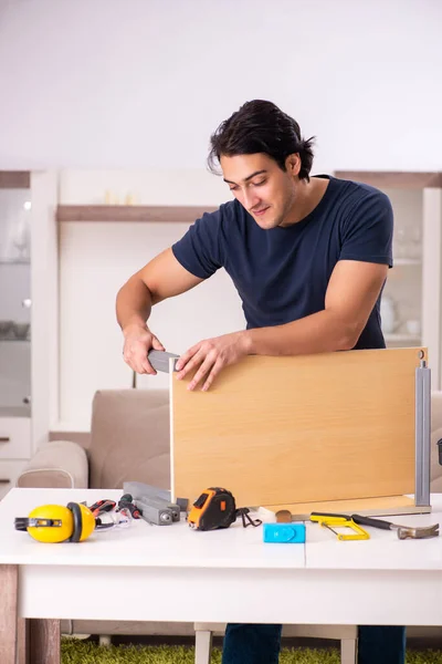 Young man repairing furniture at home
