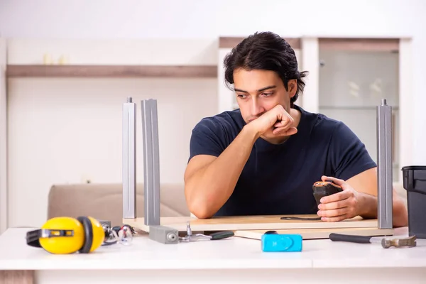 Young man repairing furniture at home