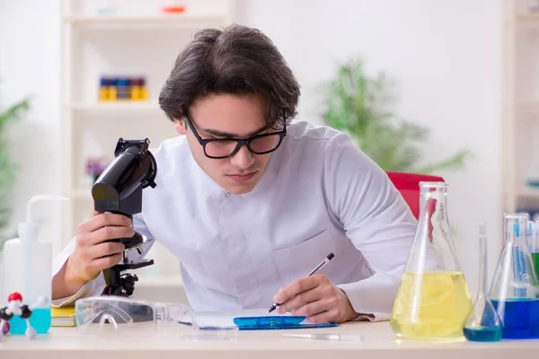 Bioquímico varón joven trabajando en el laboratorio — Foto de Stock