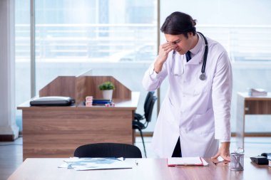 Klinikte çalışan yakışıklı genç bir doktor.