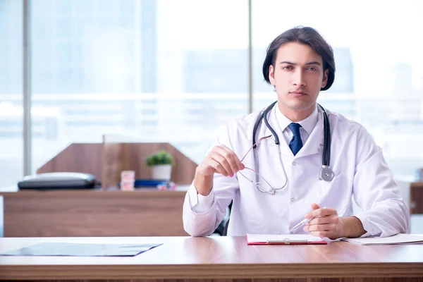 Joven médico guapo que trabaja en la clínica —  Fotos de Stock