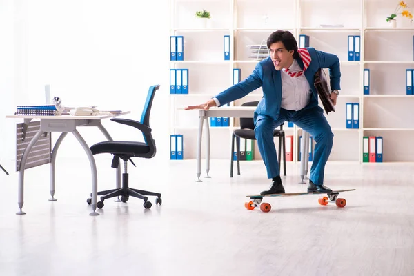 Joven hombre de negocios guapo con longboard en la oficina — Foto de Stock