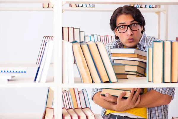 Studente maschio che si prepara per gli esami in biblioteca — Foto Stock
