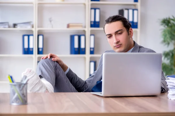 Leg injured male employee in the office — Stock Photo, Image