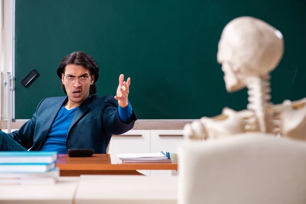 Manlig lärare och skelettelev i klassrummet — Stockfoto