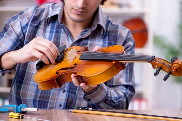 Jeune beau réparateur réparer violon — Photo