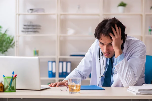 Jung männlich doktor trinken im die büro — Stockfoto