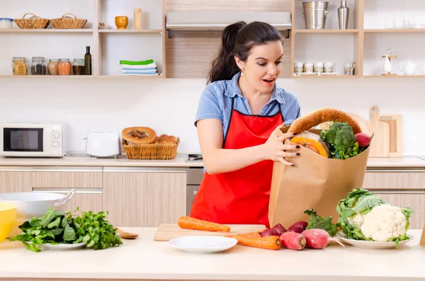 Giovane donna con verdure in cucina — Foto Stock