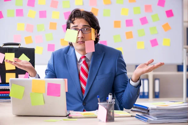 Jonge mannelijke knappe werknemer in tegenstrijdige prioriteiten concept — Stockfoto