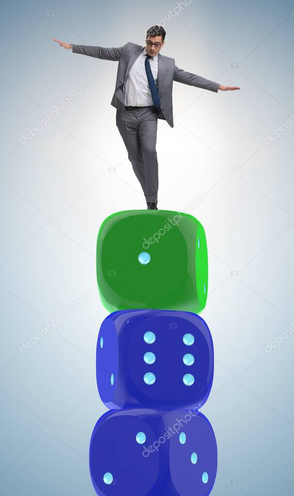 Businessman balancing on top of dice stack in uncertainty concep