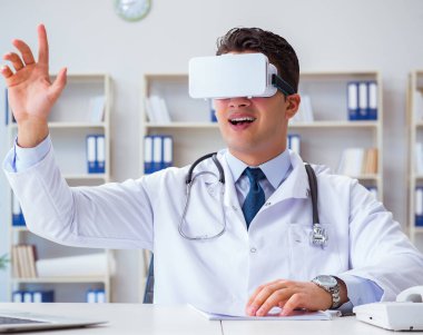 Sanal gerçeklik kulaklığı olan genç doktor ofiste çalışıyor.