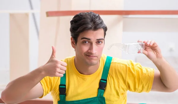 Empreiteiro que trabalha no piso de madeira laminado — Fotografia de Stock