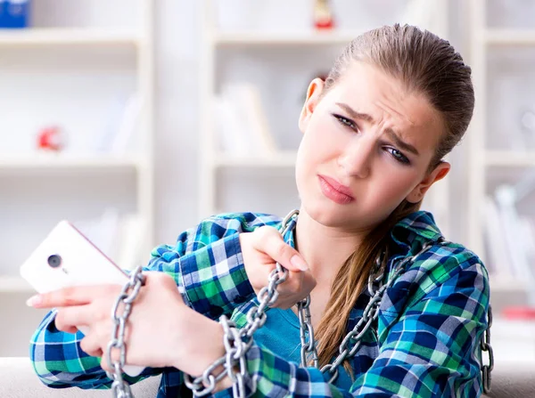 Mujer encadenada estudiante con móvil sentado en el sofá — Foto de Stock