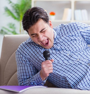 Evde karaoke yapan komik adam.