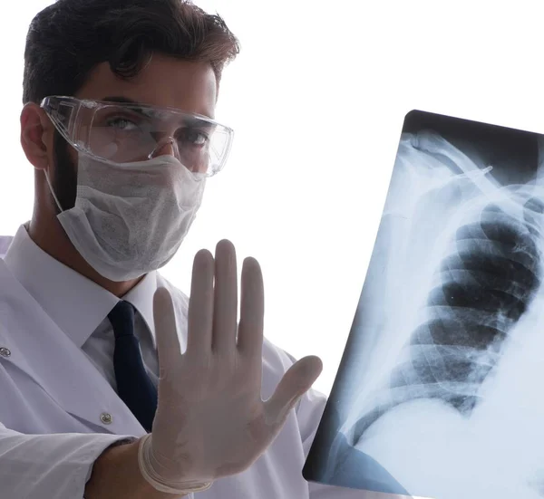 Молодой врач смотрит на рентгеновские снимки, изолированные на белом — стоковое фото