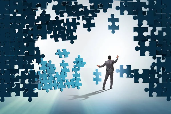 Businessman breaking the wall of jigsaw puzzle — Stock Photo, Image