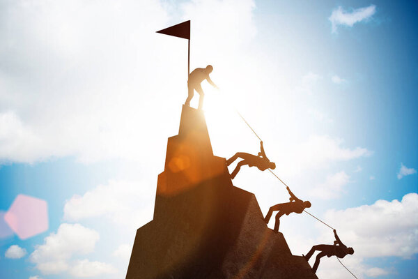 Concept of teamwork with team climbing mountain top