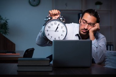 Gece ofiste çalışan genç bir erkek.