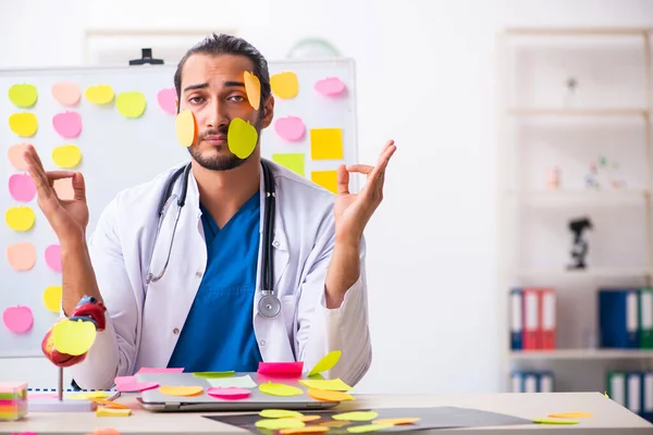 Junge männliche Mediziner in widersprüchlichem Prioritätenkonzept — Stockfoto