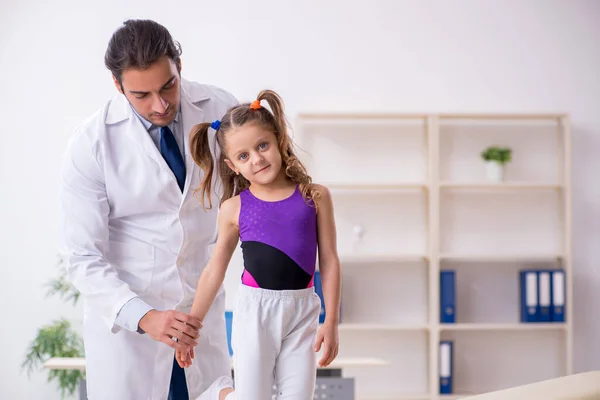 Menina pequena visitando jovem médico masculino — Fotografia de Stock