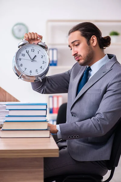 Ung manlig affärsman läser böcker på arbetsplatsen — Stockfoto