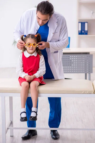 Piccola ragazza in visita giovane medico maschio oculista — Foto Stock