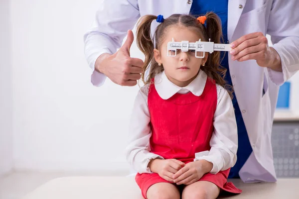 Menina pequena visitando jovem médico oculista masculino — Fotografia de Stock