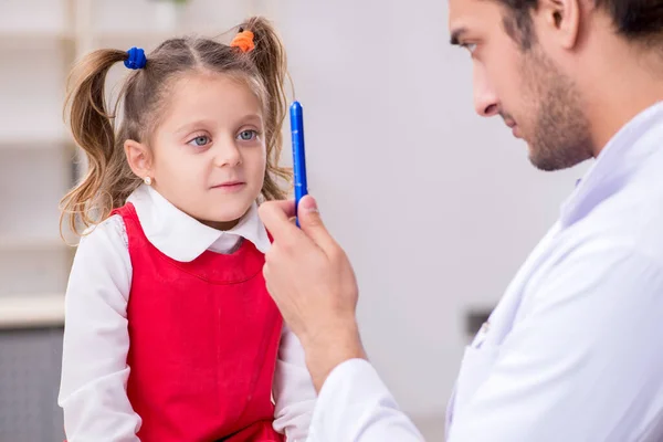 Petite fille visitant jeune médecin oculiste masculin — Photo