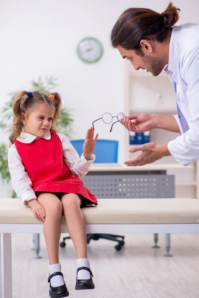 Piccola ragazza in visita giovane medico maschio oculista — Foto Stock