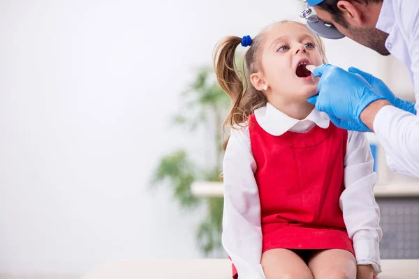 Klein meisje op bezoek bij jonge mannelijke arts otorhinolaryngoloog — Stockfoto