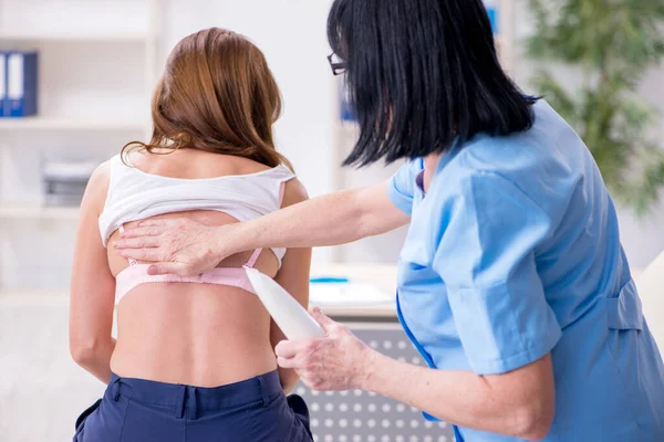 Mujer joven visitando a una vieja doctora dermatóloga — Foto de Stock