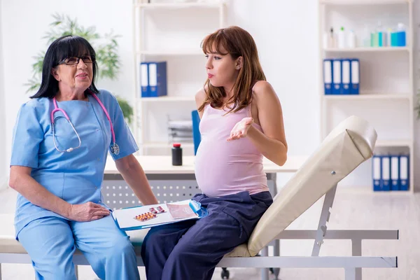 Mladá těhotná žena na návštěvě zkušený lékař gynekolog — Stock fotografie
