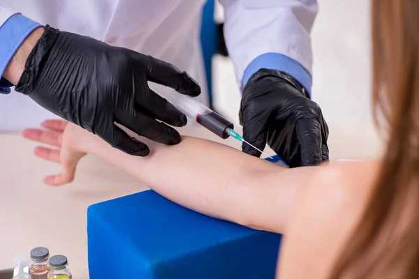 Mujer joven visitando viejo médico masculino — Foto de Stock