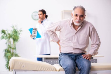 Yaşlı hasta genç erkek doktoru ziyaret ediyor.