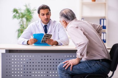 Yaşlı hasta genç erkek doktoru ziyaret ediyor.