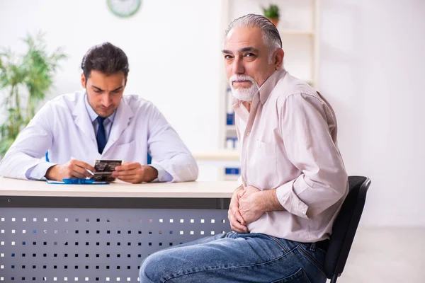 Alt patient besuch jung männlich doktor — Stockfoto