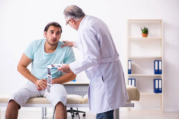 Jovem paciente do sexo masculino visitando médico experiente — Fotografia de Stock