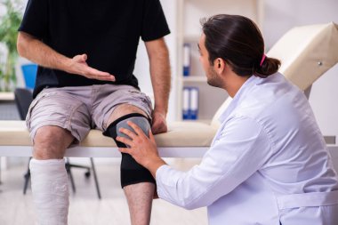 Yaşlı adam genç doktor travmatoloğu ziyaret ediyor.