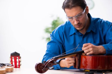 Genç erkek çello tamircisi.