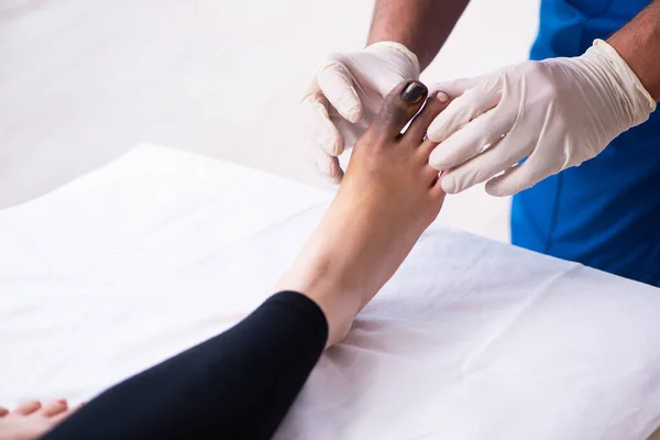 Dedo ferido mulher visitando médico traumatologista masculino — Fotografia de Stock