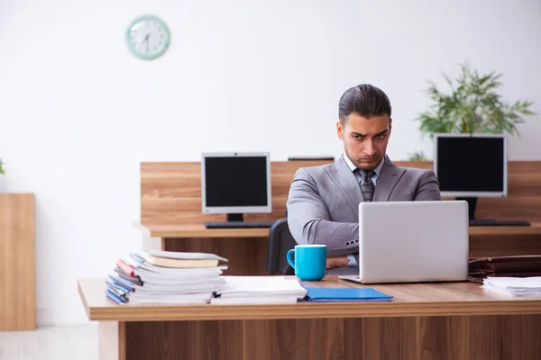 Joven empleado masculino infeliz con el trabajo excesivo —  Fotos de Stock