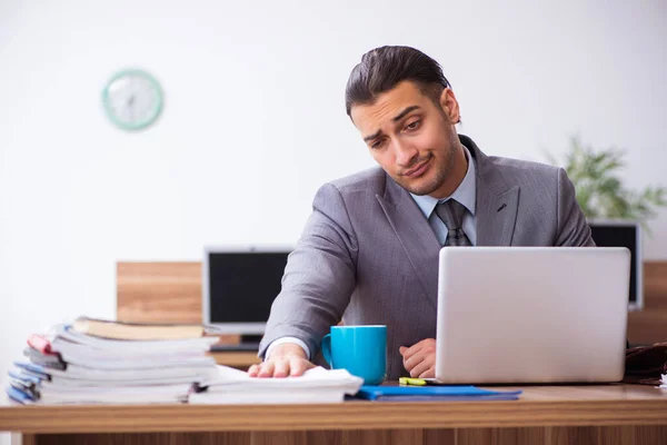 Joven empleado masculino infeliz con el trabajo excesivo — Foto de Stock