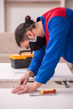 Genç marangoz salgın hastalık sırasında kapalı alanda çalışıyor.