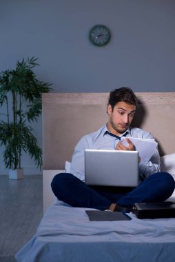 Yorgun işadamı gece fazla mesai yapıyor.