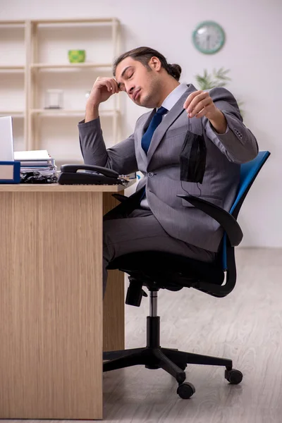 Joven empleado masculino en la oficina durante enfermedad pandémica — Foto de Stock