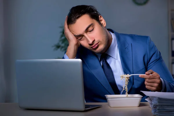 Hungriger Mitarbeiter arbeitet spät im Büro — Stockfoto