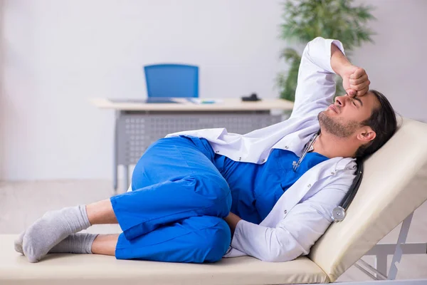Young male doctor being tired after night shift — Stock Photo, Image